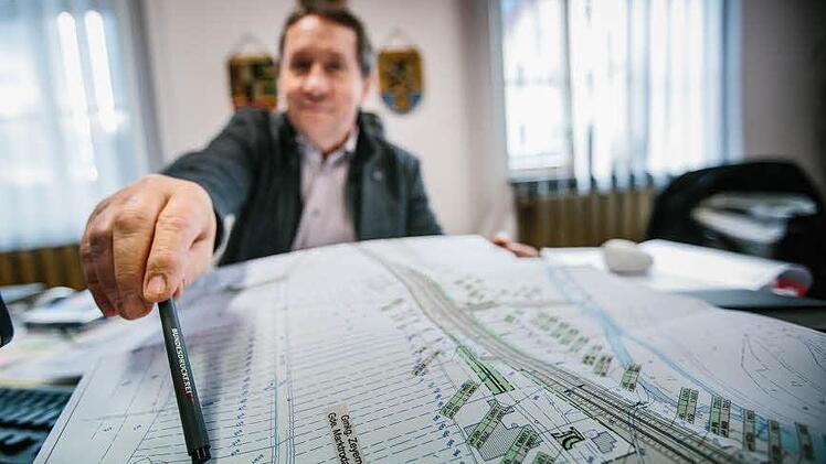 Die dicke Linie rechts auf dem Plan zeigt die kommende Ortsumgehung Zeyern. Marktrodachs Bürgermeister Norbert Gräbner weist auf einen Bereich nahe der Gemarkung. Dort könnte ein neues Misch-Baugebiet entstehen.  Foto: Hednrik Steffens