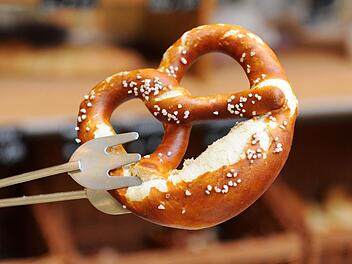 Eine Brezel wird in München in einer Bäckerei mit einer Zange gehalten. Jede fünfte Breze enthalte zu viel Aluminium, erklärte das Landesamt für Gesundheit und Lebensmittelsicherheit in Erlangen, das Aluminium gelangt über die Backbleche in die Brezen. Foto: Tobias Hase/dpa