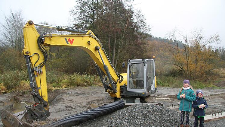 Lotta und Emil lassen sich vom Regenwetter nicht schrecken - sie schauen sich die Baumaschinen aus der Nähe an.