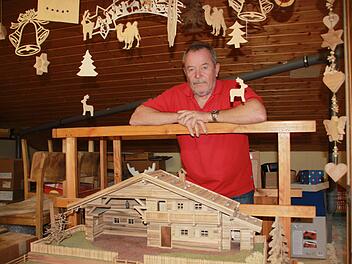 Im Dachboden seines Hauses überblickt Dietmar Bauernschmitt Krippen und Laubsägearbeiten, die er in den Weihnachtsmarktstand mitnehmen wird. Fotos: Ramona Popp