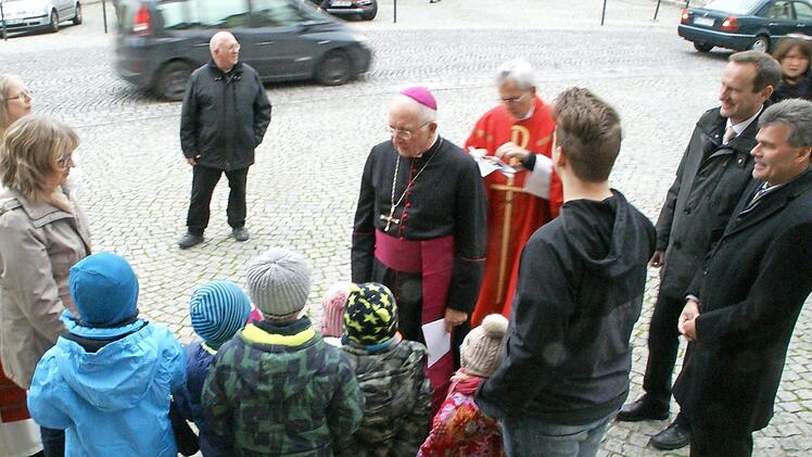 Mit einem Martinslied und selbstgemalten Bildern empfingen einige Kindergartenkinder Weihbischof Ulrich Boom in Eltmann.  Fotos: Sabine Weinbeer