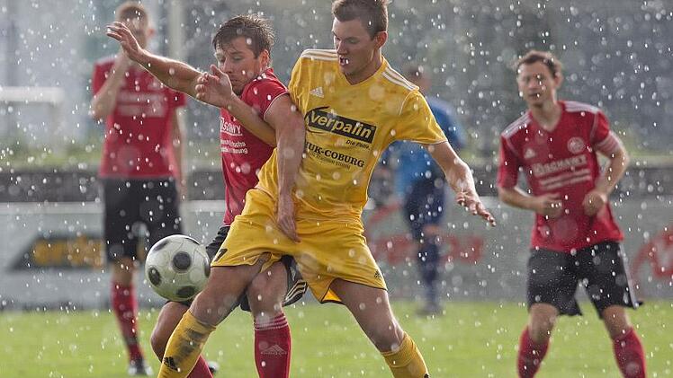 Der Eichaer Manuel Frembs (rechts) wehrt sich bei starkem Regen im Karl-Fleschutz-Stadion vehement gegen den Lichtenfelser Pascal Graf. Foto: Uwe Gick