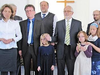 Bei der Segnung zur Amtseinführung von Pastor Sebastian Thierfelder wurden die Augen geschlossen (von links): Annett Thierfelder, Seniorpastor Bernd Heise (verdeckt), Pastor Sebastian Thierfelder, Leitungsratsmitglied Detlev Bilek, Thalitha Thierfelder, Gemeindeleiter Wolfgang Freigang, Salome und Deborah Thierfelder sowie Leitungsratsmitglied Ralf Seiler.  Foto: Martin Koch