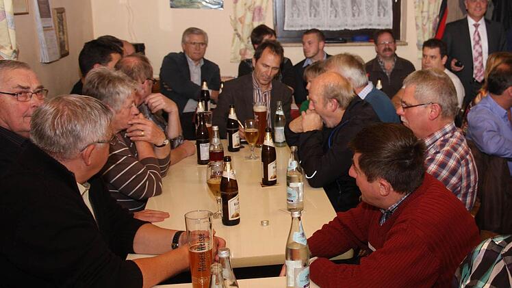 Markus Grüner, der neue Bürgermeister in Obertrubach (hinten mit Krawatte), spricht in Wolfsberg in einem gut gefüllten Sportheim.  Foto: Galster