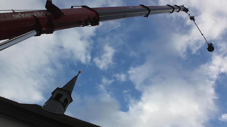 Ein Autokran hievte am Montag die Glocken der Staffelsteiner Anna-Kapelle, die restauriert worden waren, wieder an ihren angestammten Ort im Dachreiter des Kirchleins. Foto: Matthias Einwag