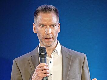 Uwe Pöhner präsentiert sich auf der Bühne des 18. Speaker-Slam s in Rheinland-Pfalz.