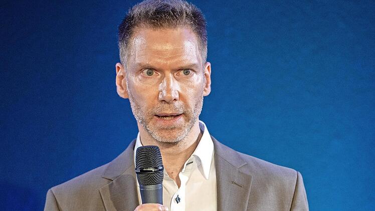 Uwe Pöhner präsentiert sich auf der Bühne des 18. Speaker-Slam s in Rheinland-Pfalz.