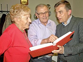 Erinnerungen sind Horst Hofmann (Mitte) besonders an seinem 80. Geburtstag wichtig. Deshalb zeigt er auch Bürgermeister Jens Korn (re) und seiner Ehefrau Helga sein kleines Fotoalbum mit vielen alten Aufnahmen.  Foto: Susanne Deuerling