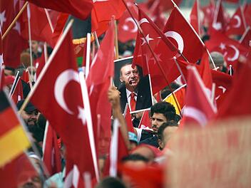 Anhänger des türkischen Staatspräsidenten Erdogan halten am 31. Juli in Köln Fahnen hoch. Foto: Henning Kaiser, dpa