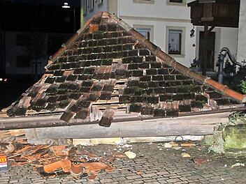 Da hatte es gerumst: Das Dach des Gleusdorfer Brunnenhäuschens liegt am Boden; im Hintergrund erkennt man das Heck des Lasters , der dagegen gestoßen war. Fotos: Ralf Kestel