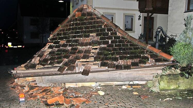 Da hatte es gerumst: Das Dach des Gleusdorfer Brunnenhäuschens liegt am Boden; im Hintergrund erkennt man das Heck des Lasters , der dagegen gestoßen war. Fotos: Ralf Kestel