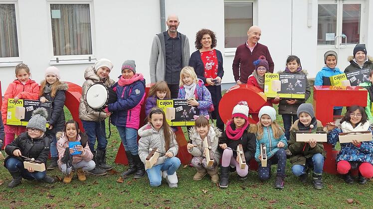 Der Leiter der Hausverwaltung Schr&ouml;der, Michael Schr&ouml;der (rechts), &uuml;berreicht Sch&uuml;lern, der Musikp&auml;dagogin Michaela Wei&szlig;enberger (Mitte) und Rektor Karl-Heinz Deublein (l.) die neuen Instrumente. Foto: Ruben Latos