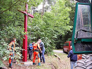 Mit Maschinenkraft wurde das fünf Meter hohe Holzkreuz an historischer Stelle aufgestellt.  Foto: Sigismund von Dobschütz