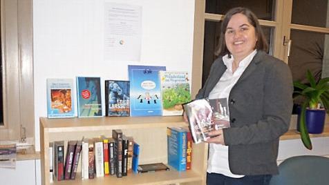 Bürgermeisterin Sonja Reubelt hat ein offenes Bücherregal im Rathaus angeschafft, bei dem sich und das jeder bedienen kann.  Foto: Marion Eckert