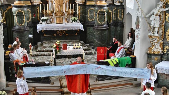 Auf einer großen Rolle waren die Fragen der Ministranten notiert, die sie bei der Katechese an Gott stellten. Pater Felix rollte sie beim Abschlussgottesdienst in der Wallfahrtskirche Ipthausen auf. Hanns Friedrich