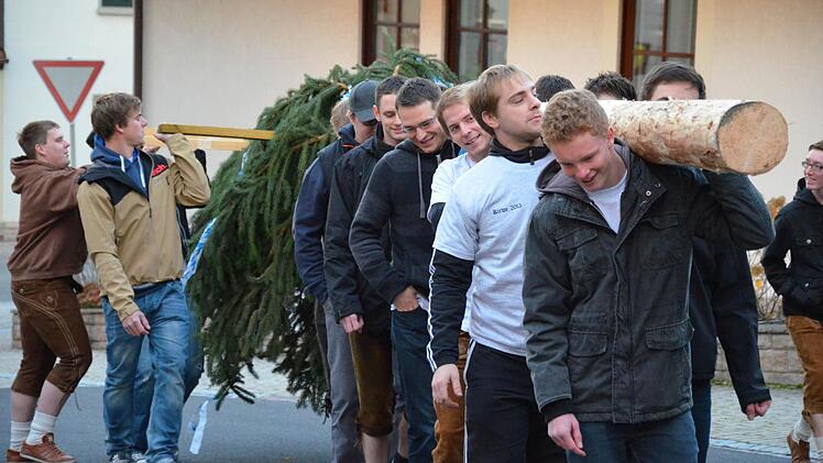 Burschen aus Ober- und Unterdorf tragen den "Kirwe-Baum" durch den Ort.