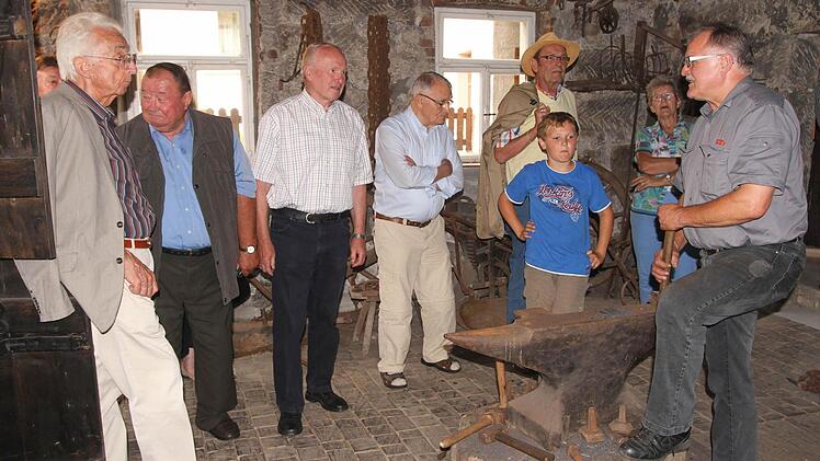 Heinz Stretz (rechts) bei der Führung und dem Schmieden am Amboss im Schmiedemuseum in Kirchlauter, von links Altlandrat Walter Keller, Theo Diem und Otto Steinmetz. Fotos: G. Geiling