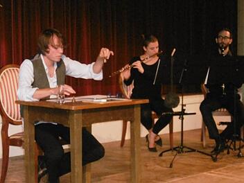 Ganz ohne Worte: Schauspieler Martin Spitzweg "spricht" mit Händen und scheinbar sinnlosen Lauten. Im Hintergrund spielen Flötistin Isabelle Soulas und Klarinettist Oliver Klenk kurze Zwischentöne für die Ferienkinder im Lola-Montez-Saal. Foto: Regina Rinke