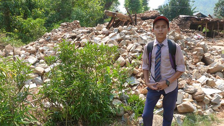 Rajdoot Silwal steht vor den Trümmern seines bisherigen Zuhauses. Der Junge ist eines von rund 130 Patenkindern der Kulmbacher Nepalhilfe.  Foto: Nepalhilfe
