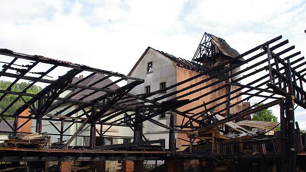 Das Höfleser Sägewerk wurde ein Raub der Flammen. Am Dienstagmorgen stand nur noch das Gebälk. Der Turm (hinten) konnte allerdings gehalten werden. Foto: Marco Meißner