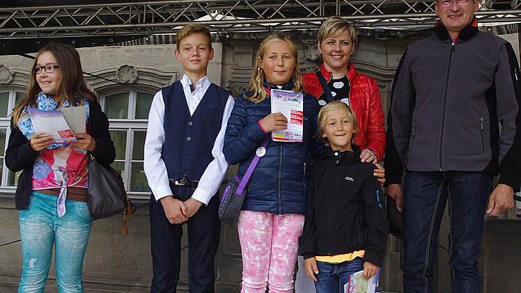 Die Preisträger der Stadtrallye (von links) Luisa Schnell, "Glücksbringer" Max, Sophia Gahn, Felix Gahn, Zweite Aktionsgemeinschafts-Vorsitzende Michaela Weiss und Erster Aktionsgemeinschafts-Vorsitzender Dietrich Denzner Foto: Heike Schülein