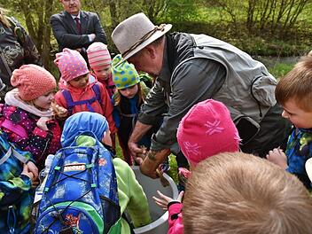 Klaus Kowalski holte für die Vorschulkinder eine Bachforelle aus dem Eimer, bevor die Ladung im Wasser landete. Fotos: Gabi Arnold