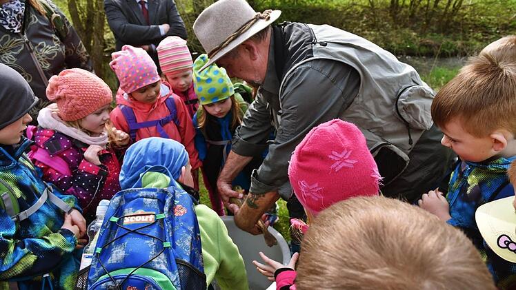 Klaus Kowalski holte für die Vorschulkinder eine Bachforelle aus dem Eimer, bevor die Ladung im Wasser landete. Fotos: Gabi Arnold