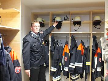 Kommandant Matthias Nürnberger greift einen Feuerwehrhelm aus einem der Spinde, die im Anbau des Lauterer Feuerwehrhauses untergebracht sind. Fotos: Björn Hein
