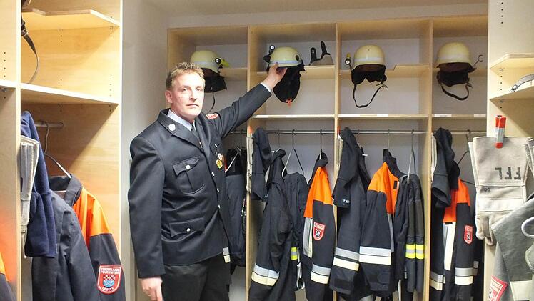 Kommandant Matthias Nürnberger greift einen Feuerwehrhelm aus einem der Spinde, die im Anbau des Lauterer Feuerwehrhauses untergebracht sind. Fotos: Björn Hein
