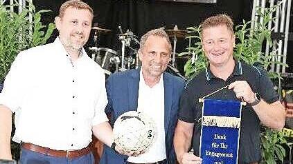 Thorsten Glauber (M.) überreicht ein Ehrenband und einen Fußball an Vorsitzenden Alexander Ruf (r.) und Zweiten Vorsitzenden Thomas Holzapfel.