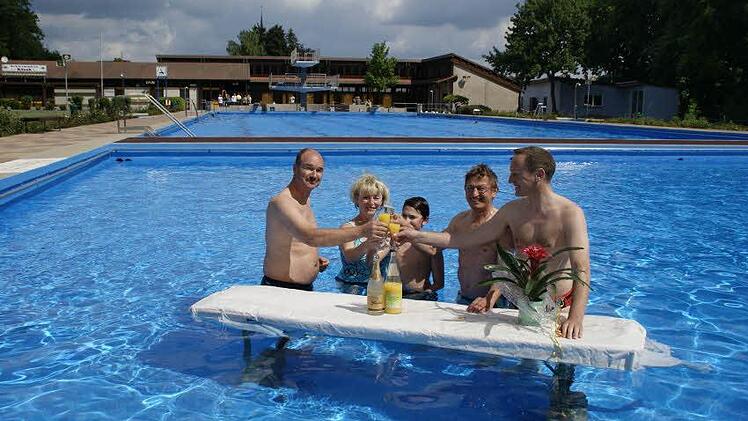 Zur Saisoneröffnung lassen sich Bürgermeister Michael Ziegler und der für das Freibad zuständige Beamte Wolfgang Tully (von rechts) immeretwas Originelles einfallen - beispielsweise eine Sektbar im Wasser.