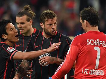 Im vergangenen Jahr standen sich der 1. FC Nürnberg (2. Liga) und Eintracht Frankfurt (1. Liga) gegenüber. In dieser Szene des Hinspiels diskutieren die Frankfurter Spieler Makoto Hasebe, Alex Meier und Marco Russ mit Nürnbergs Keeper Raphael Schäfer (von links nach rechts). Foto: Arne Dedert/dpa