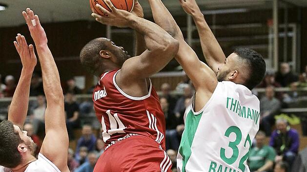Daniel Schmidt (l.) und Johannes Thiemann (r.) versuchen, den K&ouml;lner Jonathan Malu am Korberfolg zu hindern. Fotos: sportpress