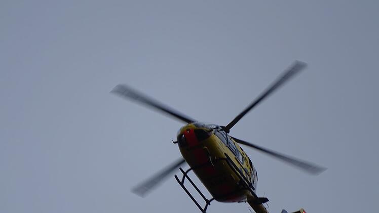 Ein Hubschrauber fliegt am 21. Juli 2025 über das Würzburger Stadtgebiet nahe des Mainufers, um mögliche Hilferufe zu untersuchen.