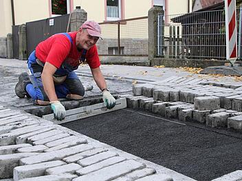 Hier wird noch ausgebessert: Dieter Schmitt setzt die letzten Pflastersteine auf dem Teilstück Sparkassenstraße/Sinnaustraße. Fotos: Ulrike Müller