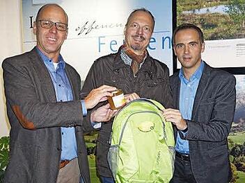 Wildfleckens Bürgermeister Gerd Kleinhenz, Klaus Spitzl und Jürgen Metz haben den Biosphärenreservats-Jubiläumsrucksack mit einem Glas Bienenhonig gefüllt. Foto: Marion Eckert