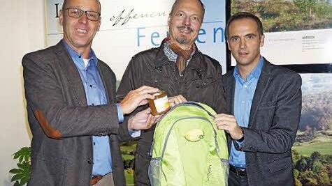 Wildfleckens Bürgermeister Gerd Kleinhenz, Klaus Spitzl und Jürgen Metz haben den Biosphärenreservats-Jubiläumsrucksack mit einem Glas Bienenhonig gefüllt. Foto: Marion Eckert