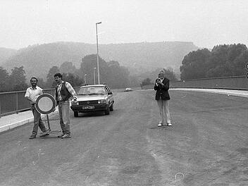 Mitarbeiter der Baufirma machten vor 30 Jahren den Weg frei für die ersten Autos auf einem Teilstück der neuen Entlastungsstraße. Die Münnerstädterin Hildegard Dallner hatte für diesen Anlass einen Sekt mitgebracht.Archiv Saale-Zeitung