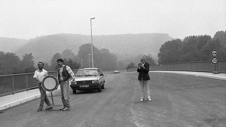 Mitarbeiter der Baufirma machten vor 30 Jahren den Weg frei für die ersten Autos auf einem Teilstück der neuen Entlastungsstraße. Die Münnerstädterin Hildegard Dallner hatte für diesen Anlass einen Sekt mitgebracht.Archiv Saale-Zeitung