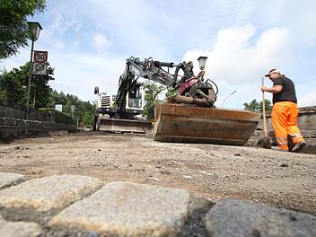 Sobald das alte Erdreich abgetragen ist, wird Mineralbeton als Frostschutzschicht aufgetragen. Darüber kommt eine Schicht Pflastersplitt, auf der dann der neue Straßenbelag Halt finden soll.