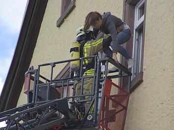Gleich ist es geschafft: Mit einer Drehleiter rettet ein Feuerwehrmann eine junge Frau aus der Alten Schule. Foto: Gerd Schaar