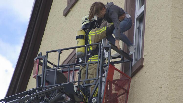 Gleich ist es geschafft: Mit einer Drehleiter rettet ein Feuerwehrmann eine junge Frau aus der Alten Schule. Foto: Gerd Schaar