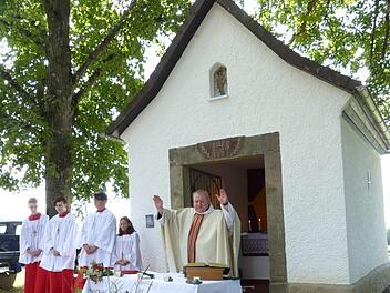 Pfarrer Pater Adrian Manderla segnete die vor dem Altar ausgelegten Kräuterbuschen und weihte die in neuem Glanz erstrahlende Sebastian-Kapelle an der Dörnhofer Straße. Fotos: Klaus-Peter Wulf