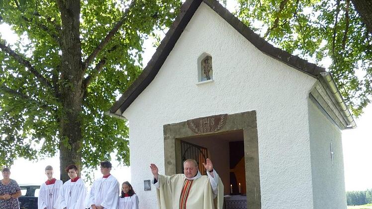 Pfarrer Pater Adrian Manderla segnete die vor dem Altar ausgelegten Kräuterbuschen und weihte die in neuem Glanz erstrahlende Sebastian-Kapelle an der Dörnhofer Straße. Fotos: Klaus-Peter Wulf