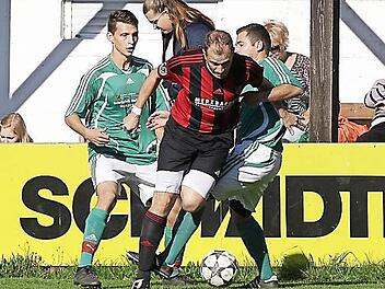 Den Unteroberndorfer Spielertrainer Wolfgang Walde nehmen die Melkendorfer Sebastian Steinmetz (l.) und Tobias Neundörfer in die Zange; rechts der Unteroberndorfer Stefan Gunzelmann. Fotos: sportpress