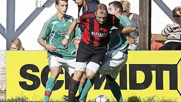 Den Unteroberndorfer Spielertrainer Wolfgang Walde nehmen die Melkendorfer Sebastian Steinmetz (l.) und Tobias Neundörfer in die Zange; rechts der Unteroberndorfer Stefan Gunzelmann. Fotos: sportpress