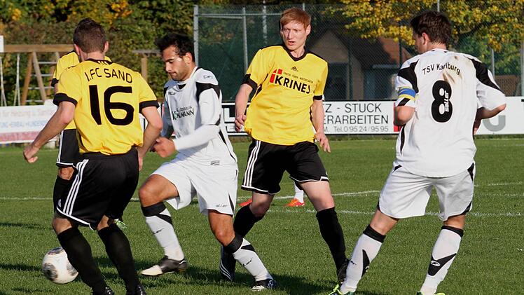 Auch hier verhindern die beiden Karlsburger den Sandern Fabian Benkert (Nr. 16) und Stefan Krines (2. von rechts) im Strafraum eine Torchance. Foto: Günther Geiling