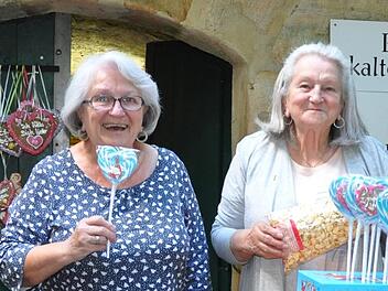 Eveline Melchior und ihre Schwester Karin Jonas bieten Süßigkeiten vor dem Gewölbestollen am Schweizer-Keller in Reuth an.  Foto: Leo Hühnlein