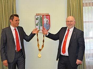 Amtsübergabe in Weißenbrunn. Der neue Bürgermeister Jörg Neubauer (links) nimmt aus den Händen des scheidenden Rathauschefs Egon Herrmann die Amtskette entgegen. Foto: K.- H. Hofmann