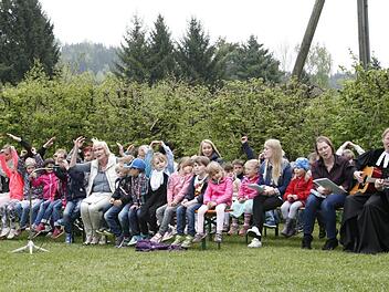 Den Festgottesdienst unter freiem Himmel, den Pfarrerin Sigrun Wagner (rechts) auf dem Gelände des Badesee unweit ihres Kinderhauses hielt, gestalteten die Jungen und Mädchen und das Betreuungsteam um Waltraut Bauer (Mitte) mit. Foto: Klaus Klaschka